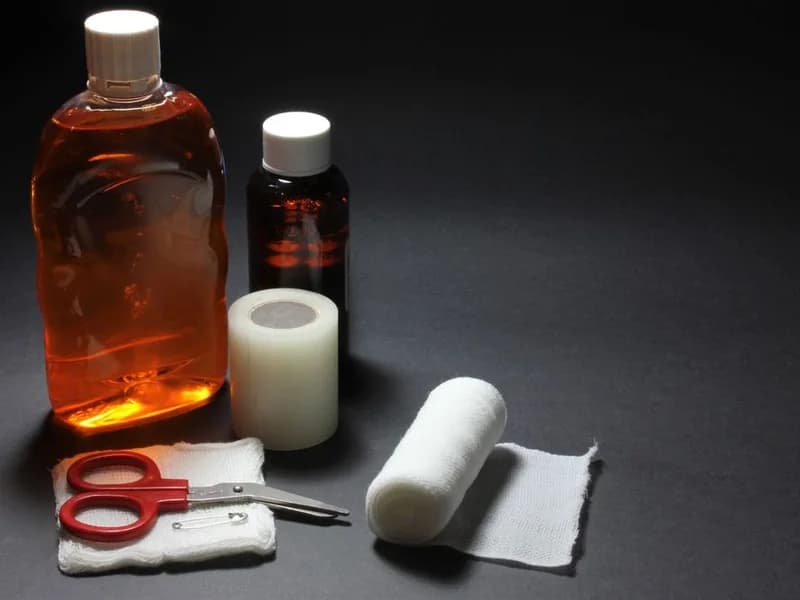 Bandages, scissors and disinfectant bottles arranged on a work surface
